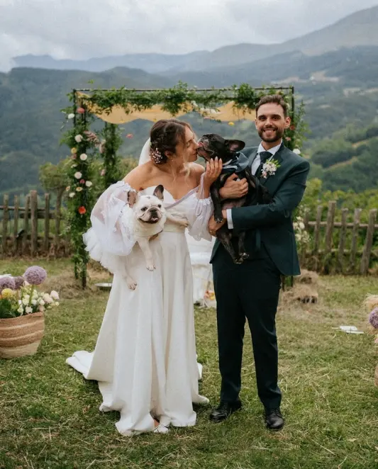 Gli sposi con i due bulldog francesi nei loro look coordinati durante il matrimonio